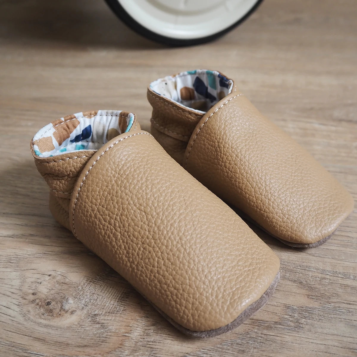 Patron de chaussons en cuir pour bébé de la marque Deco Cuir, illustration montrant le modèle et les détails du design.