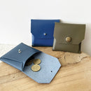 Livre et patron Deco Cuir pour mini pochette sans couture, montrant un guide étape par étape avec un exemple de pochette en cuir.