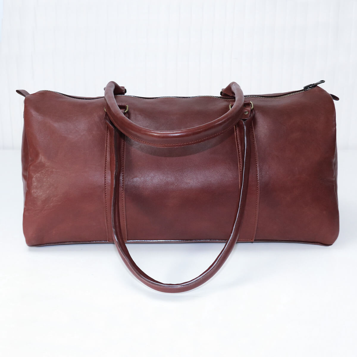 Peau entière de cuir de basane acajou, finition aniline, pour sac de voyage, couleur chaude et texture lisse.