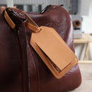 Étiquette de bagage en cuir pour kit DIY Deco Cuir, montrant une étiquette de voyage en cuir avec boucle et décoration artisanale.
