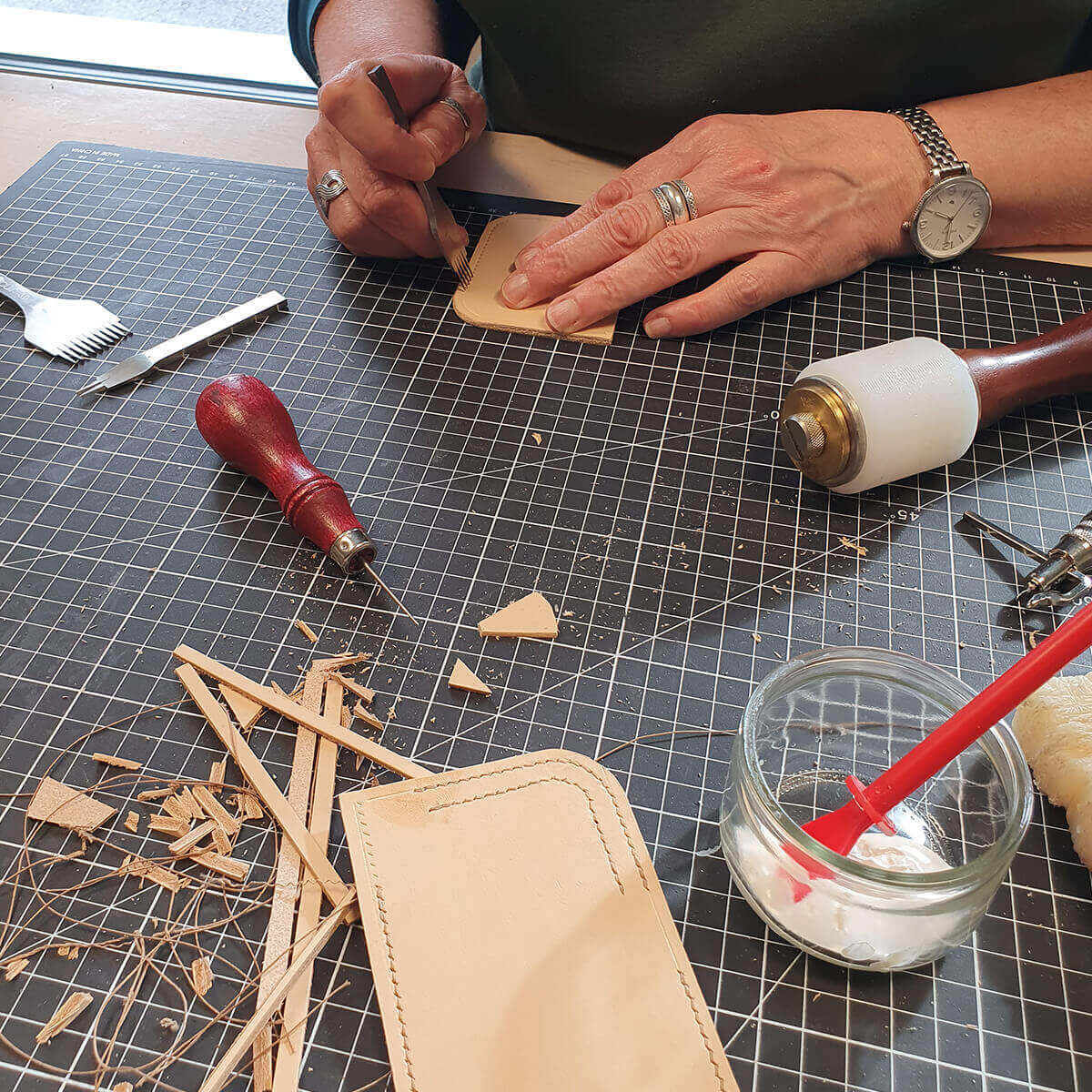 Formation couture en cuir point sellier par Deco Cuir, initiation et perfectionnement, montrant des outils et pièces de cuir.