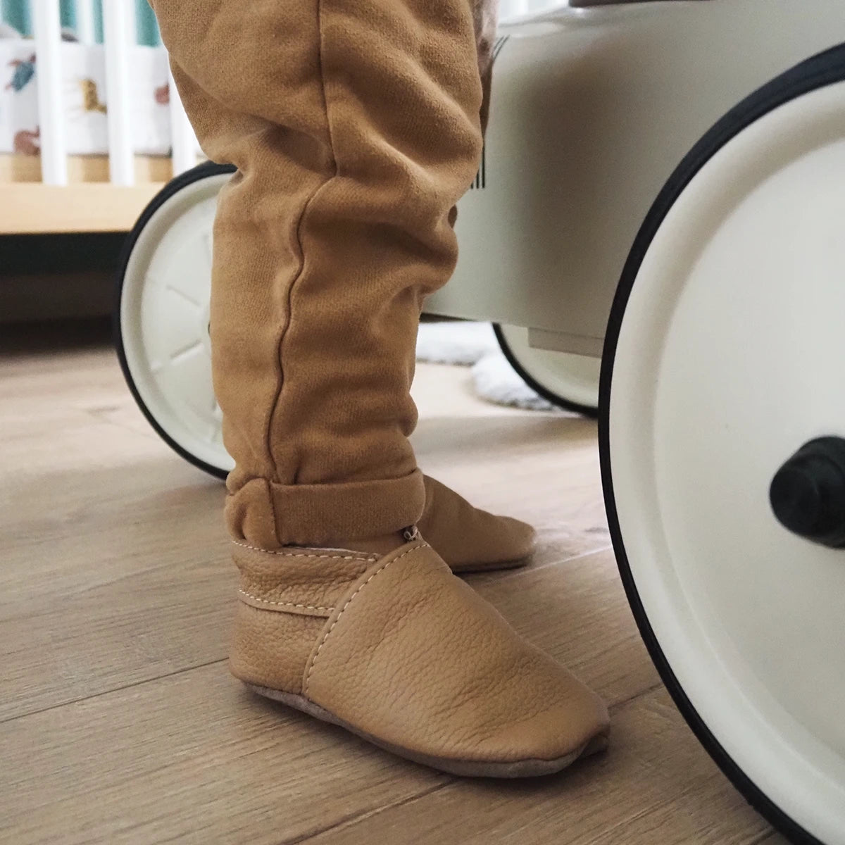 Patron de chaussons pour bébé en cuir de Deco Cuir, modèle à coudre, illustré sur un fond blanc.