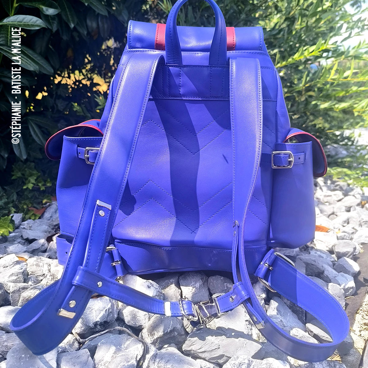 Sac à dos en peau de cuir de veau bleu Satinlys, fabriqué par Autres, avec une finition élégante et détails en cuir naturel.