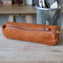 Trousse ronde en cuir beige, kit DIY Deco Cuir avec outils et matériaux pour création artisanale.