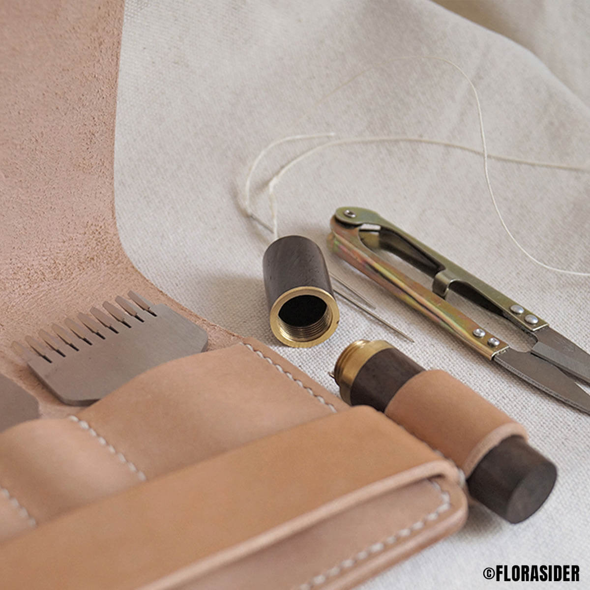 Boîte en bois et laiton pour aiguilles à coudre de la marque Deco Cuir, avec compartiments pour accessoires de mercerie.