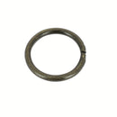 Anneau rond en acier et laiton vieilli, pièce de bouclerie artisanale, visible avec une finition patinée et texturée.