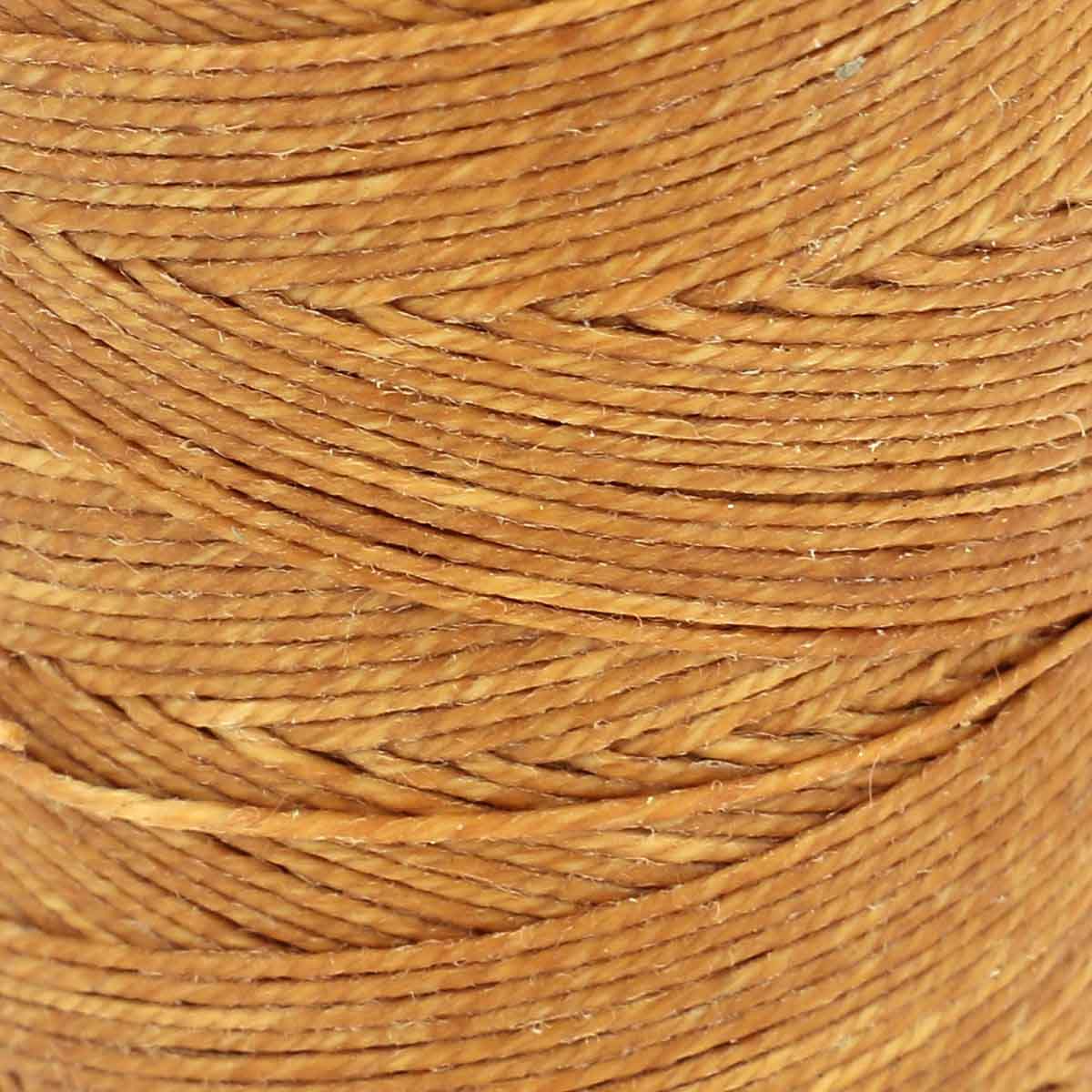 Bobine de fil de lin poissé couleur caramel au beurre, mercerie Campbell's, enroulée sur une bobine, vue de face.