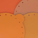 Découpe en cuir orange pour bourse, fabriquée par Deco Cuir, montrant la texture et la forme de la pièce.