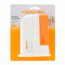 Aiguiseur de ciseaux universel Fiskars, outil pour affûter facilement tous types de ciseaux, image montrant l'outil en action.