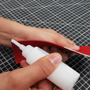 Trois bidons en plastique de 30ml contenant de la colle pour cuir, avec un applicateur en bombeur pour le travail du cuir.