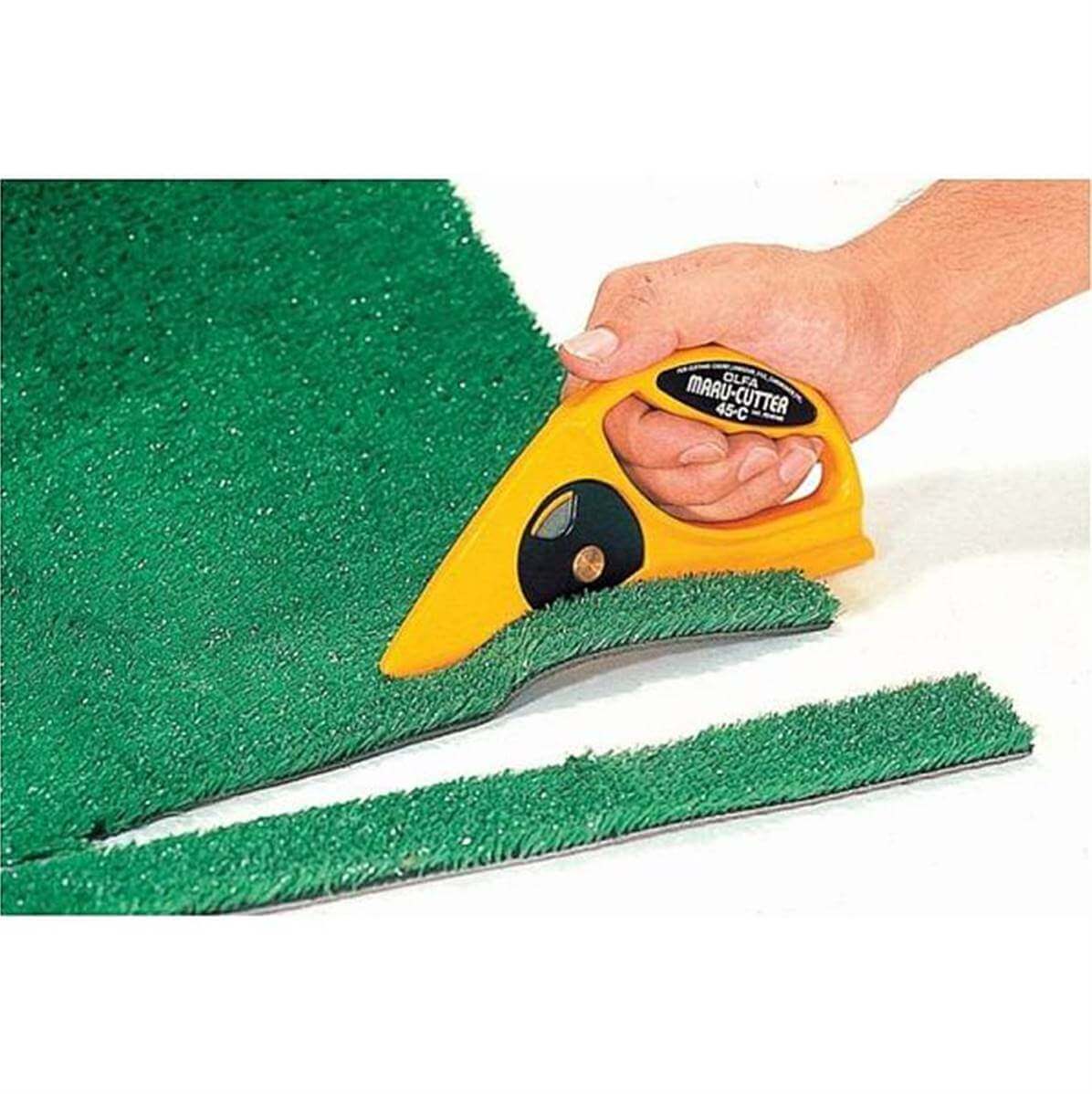 Cutter spécial cuir épais OLFA 45-C avec lame robuste sur tapis en lino, outil précis pour coupe de matériaux résistants.