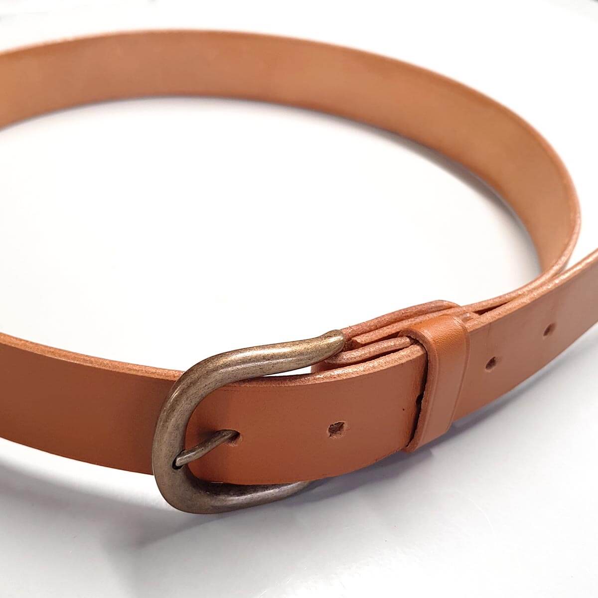 Formation Deco Cuir pour débutants : fabrication d'une ceinture en cuir artisanale avec outils et matériaux visibles.