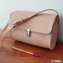 Fermeture de cartable TUCK en métal de 20x36mm pour accessoires, porté sur un sac en cuir végétal naturel.